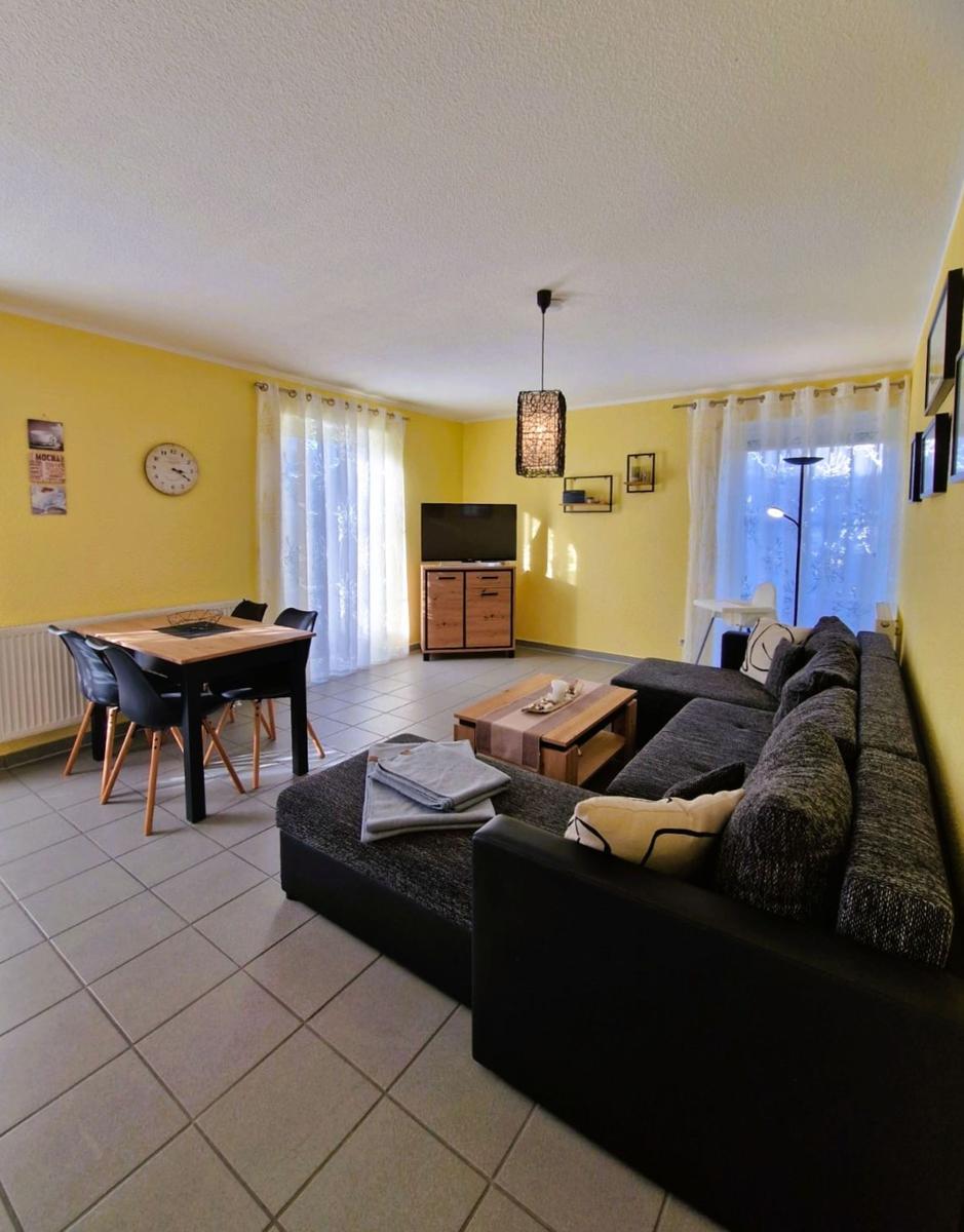 Wohn- und Essbereich mit Sofa, Tisch und Fernseher.
