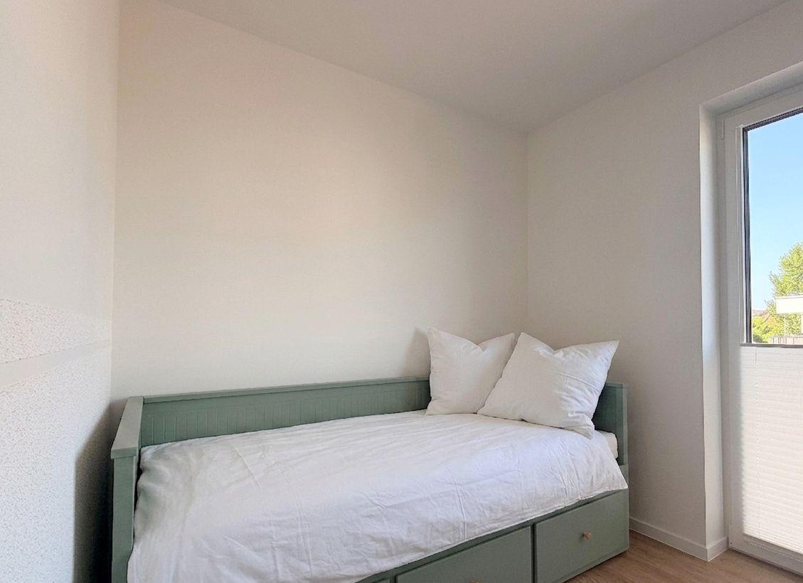 Ein Schlafzimmer mit einem Bett und einem Fenster.