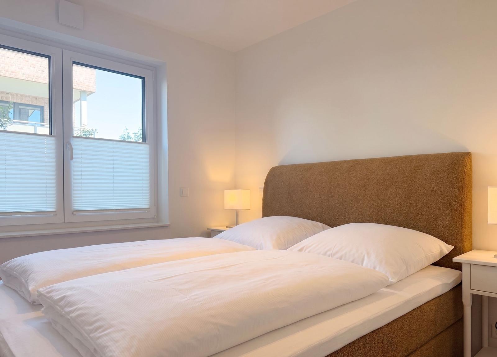 Schlafzimmer mit Doppelbett, Fenster und Nachttisch