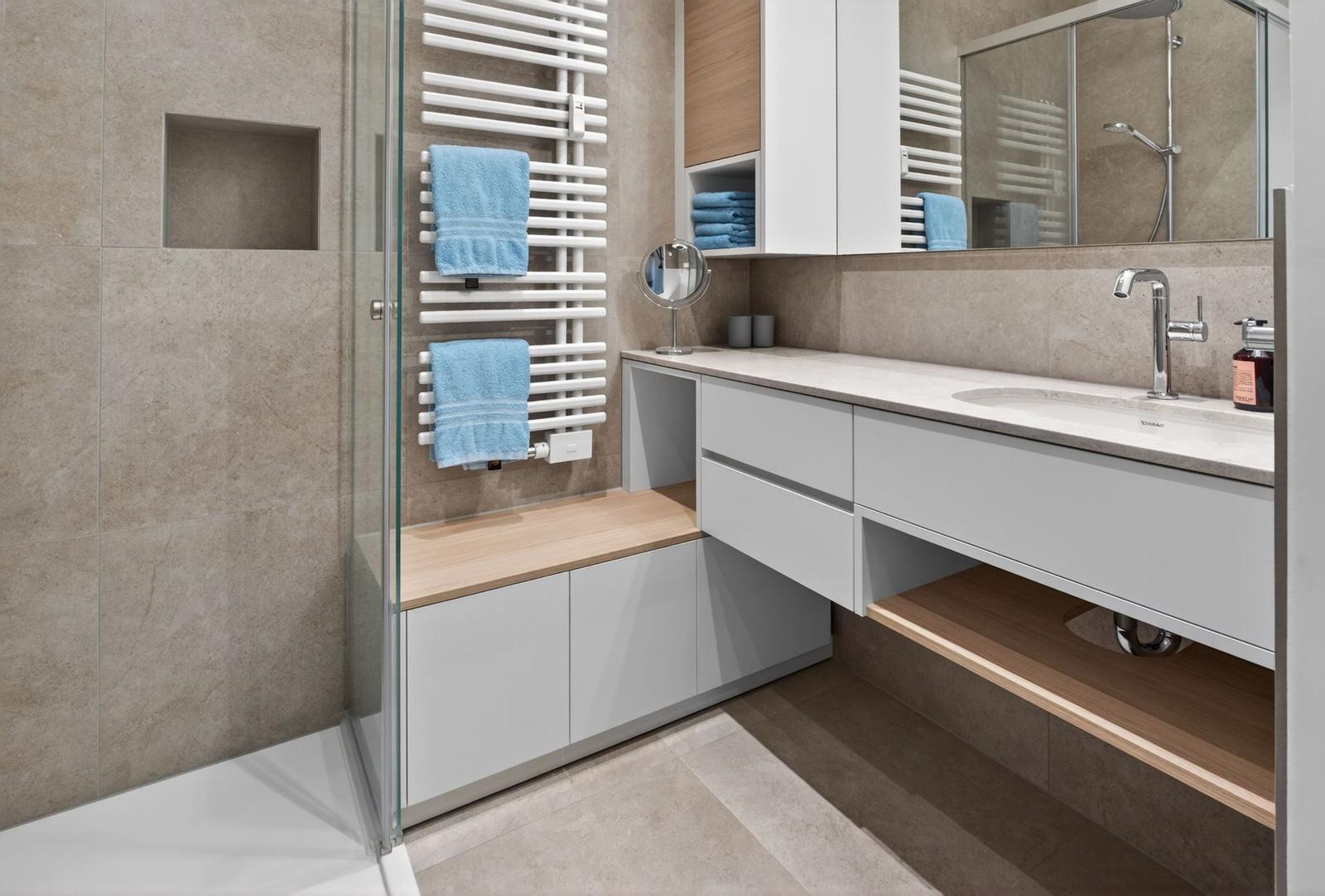 Moderne Badewanne mit Dusche, Waschbecken und Heizkörper.