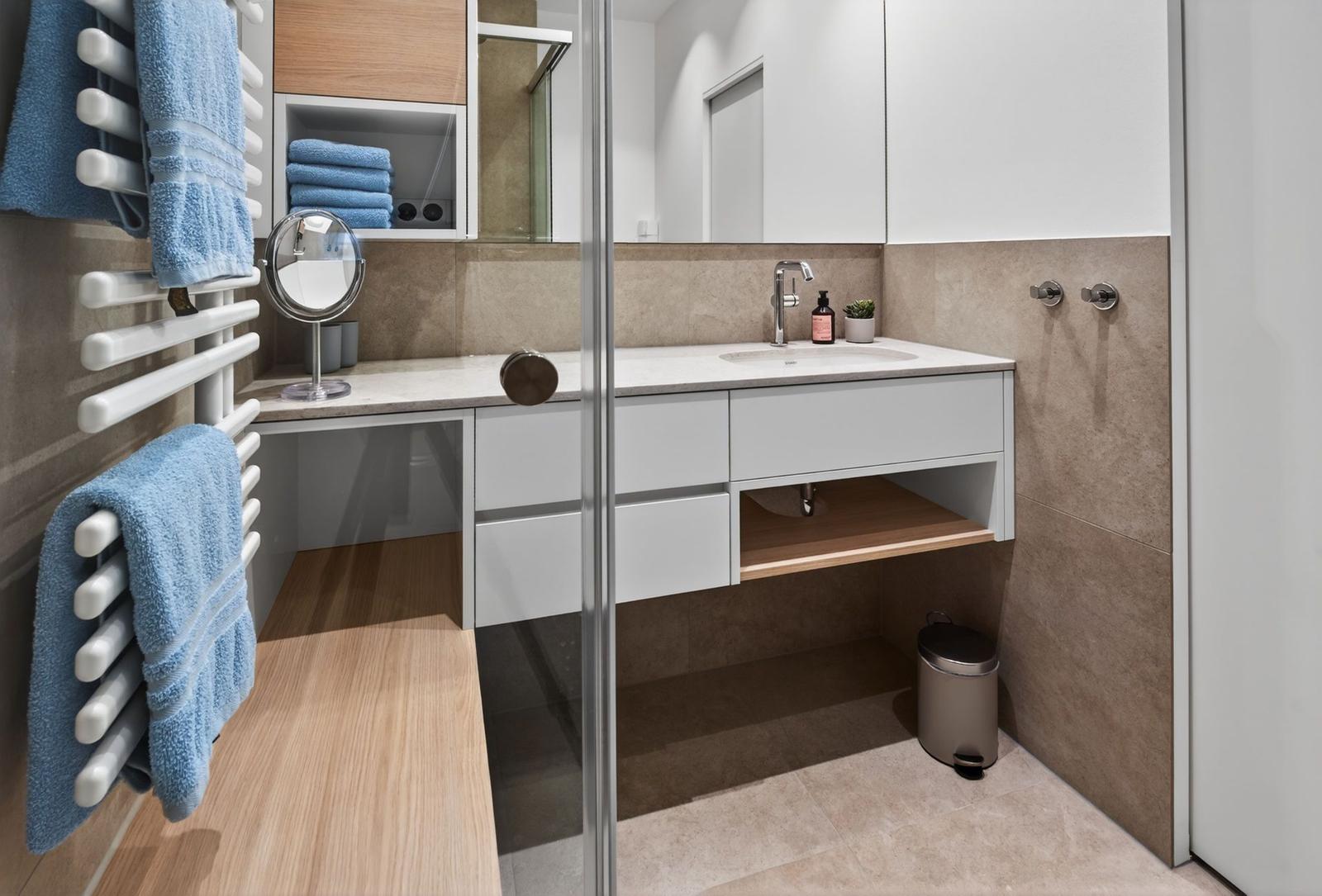 Badezimmer mit Waschbecken, Spiegelschrank und Handtuchhalter.