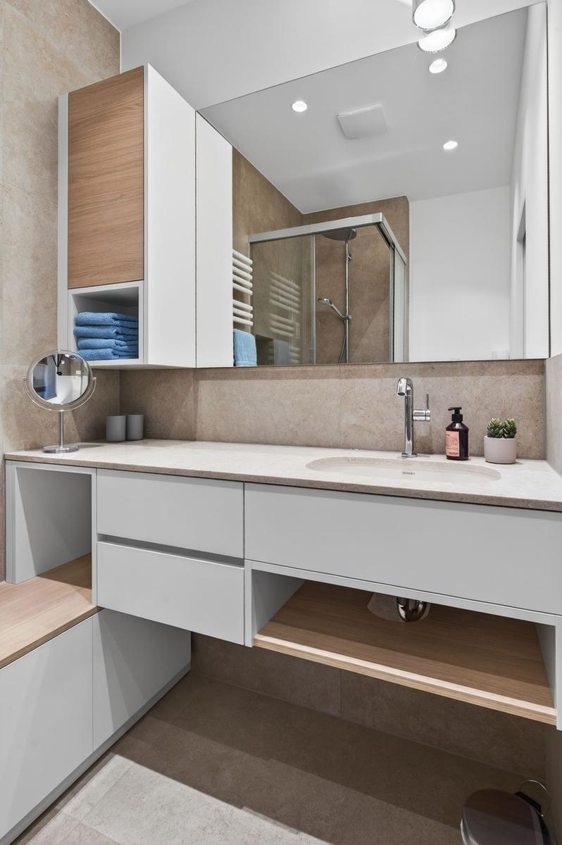 Moderne Badewanne mit Waschbecken, Spiegel und Dusche.