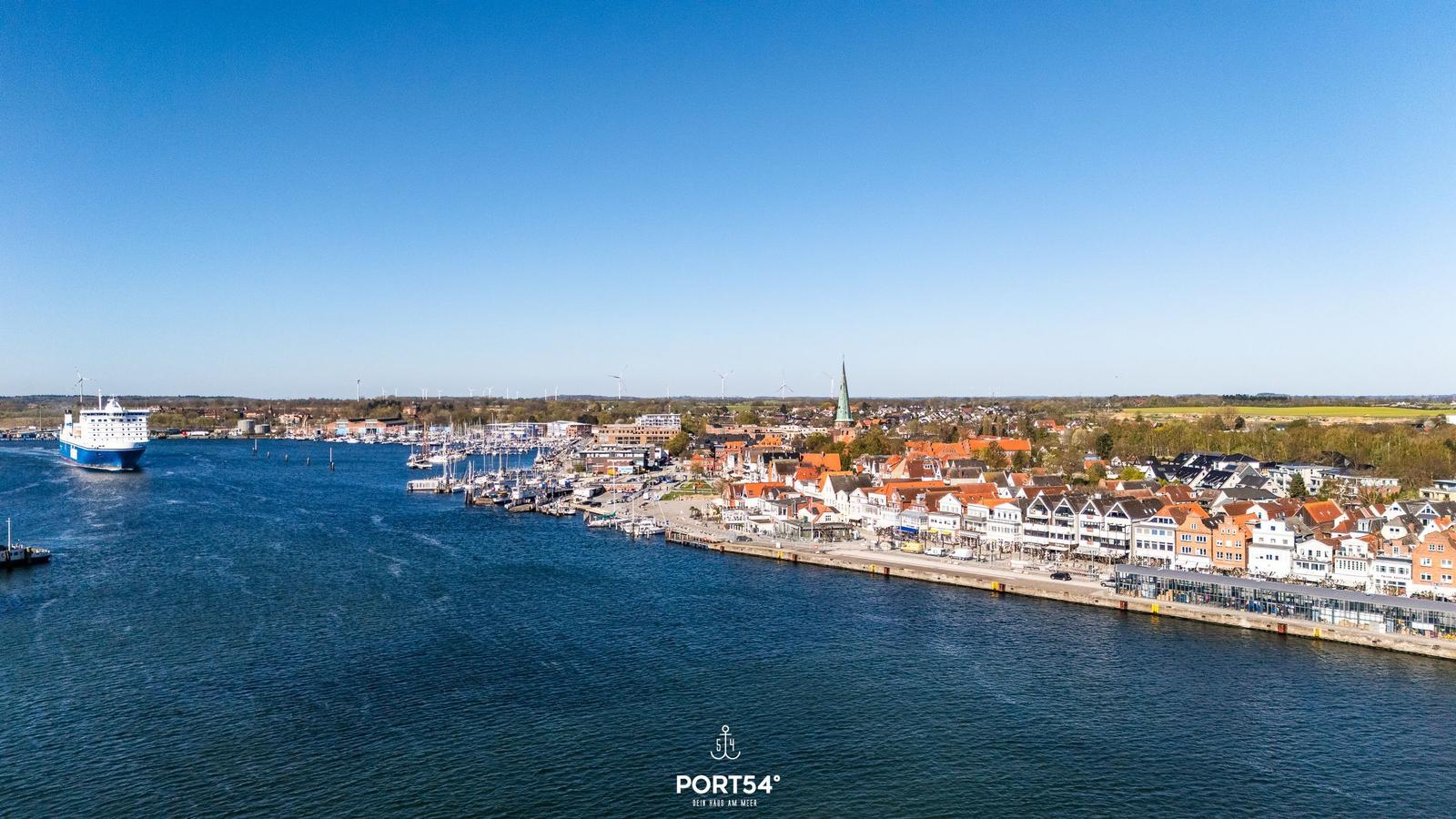 Hafenstadt mit Booten und Segelbooten am Wasser. Blick auf die Stadt mit roten Dächern.