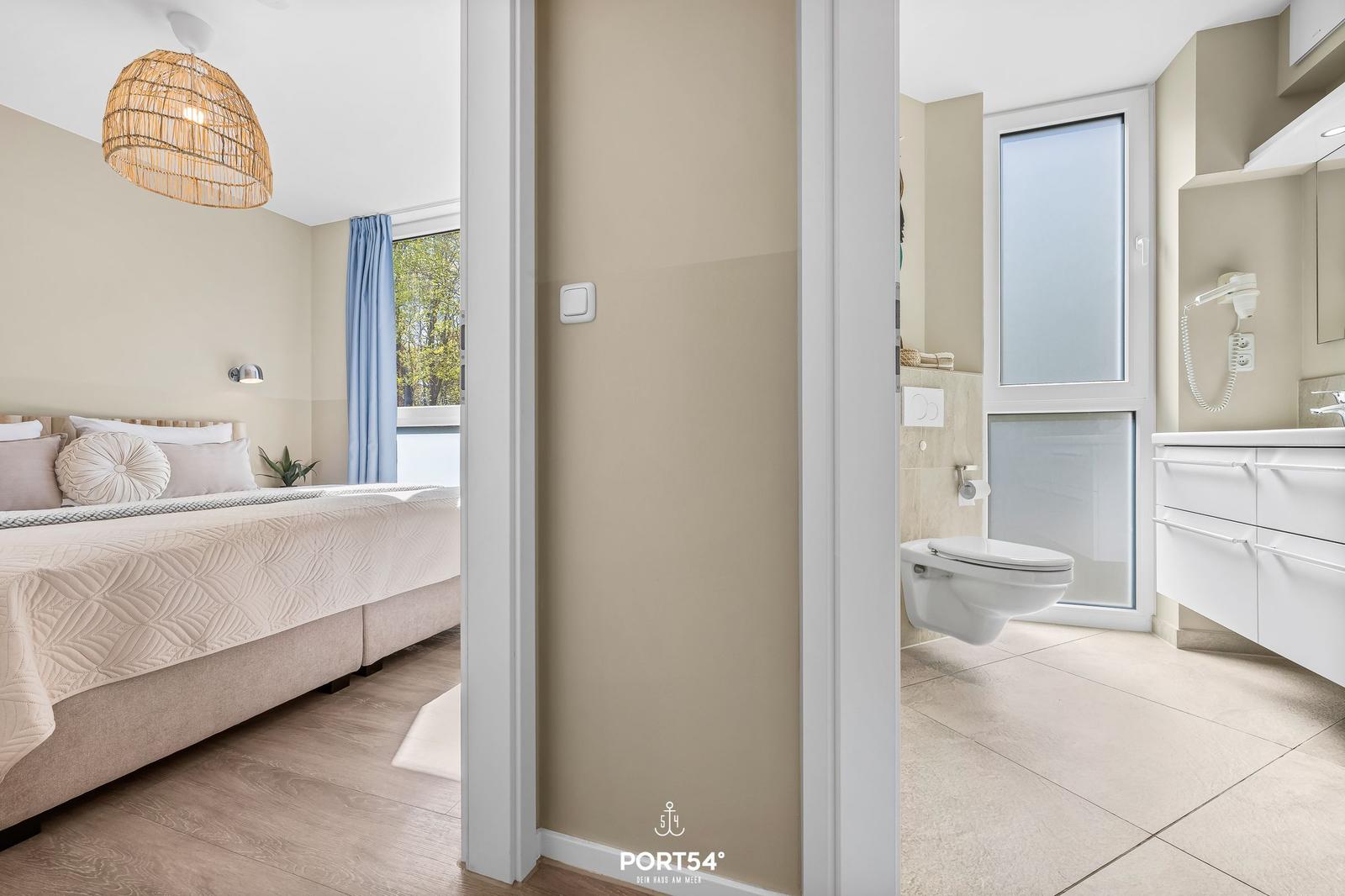 Schlafzimmer mit Bett und Bad mit Toilette und Waschbecken