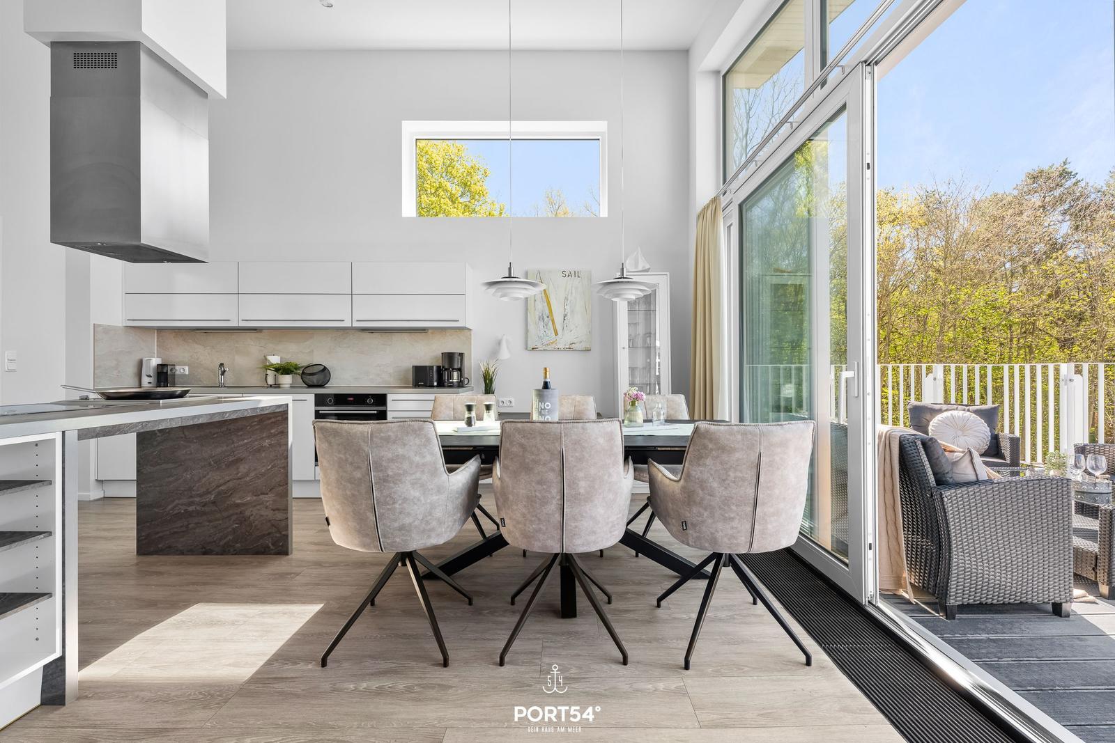 Moderne Küche mit Essbereich und Blick auf die Terrasse mit Garten.