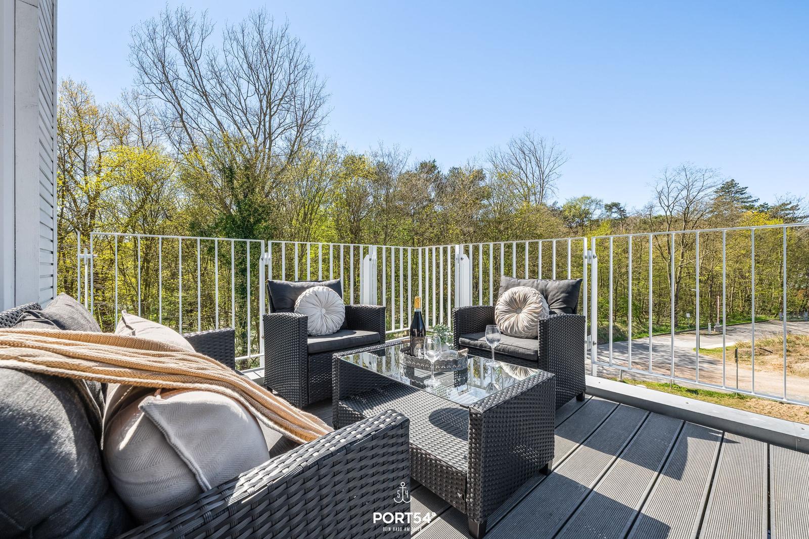 Terrasse mit Sitzgruppe und Blick auf Wald.