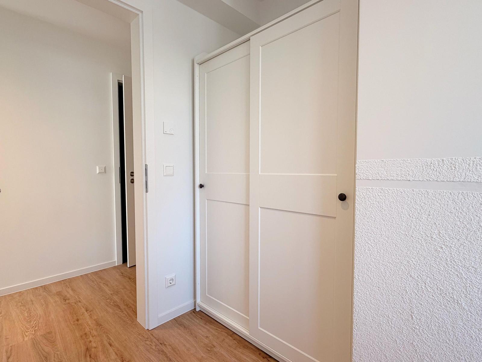 Schlafzimmer mit Schiebetüren und Holzboden