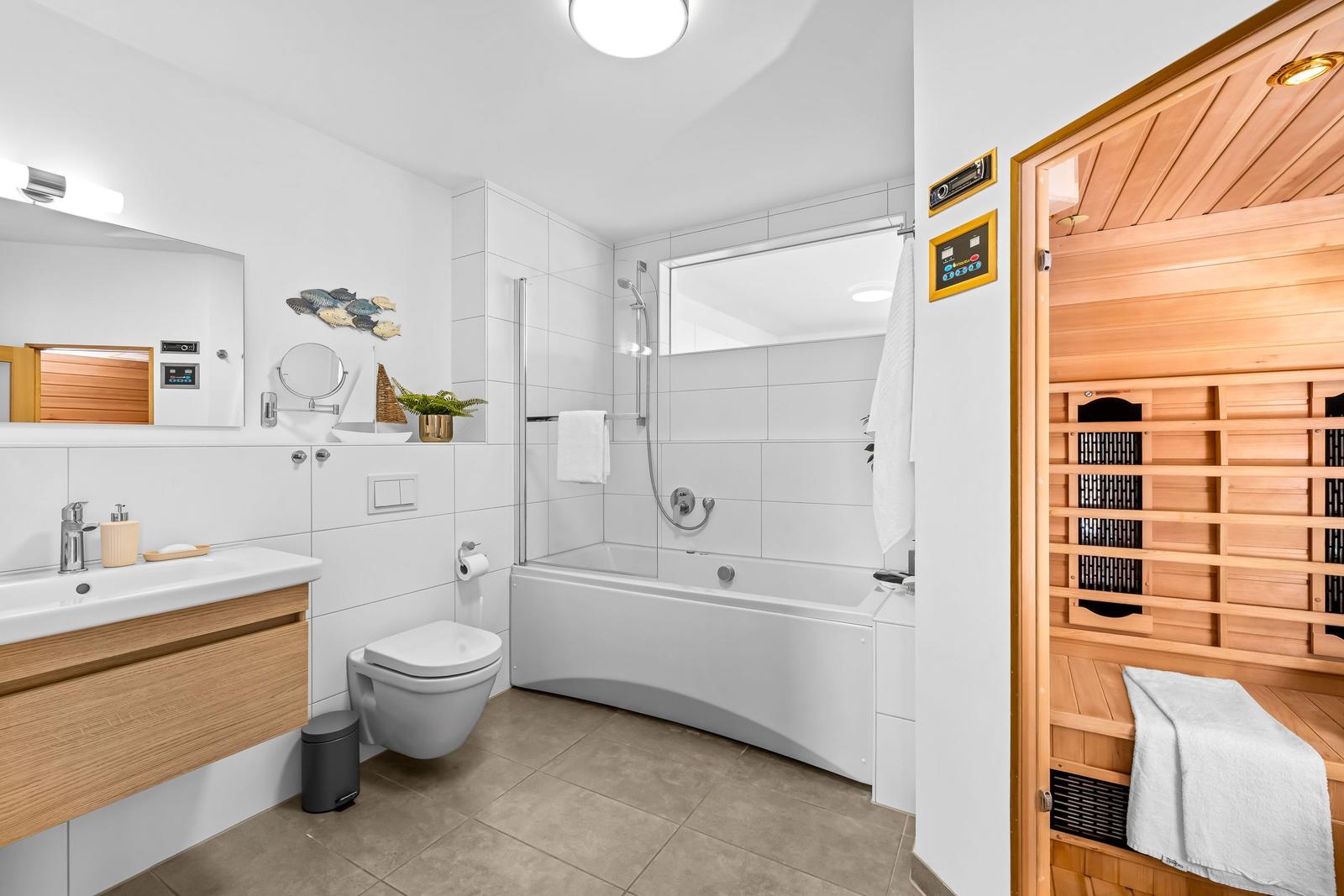 Bad mit Dusche, Badewanne und Sauna.