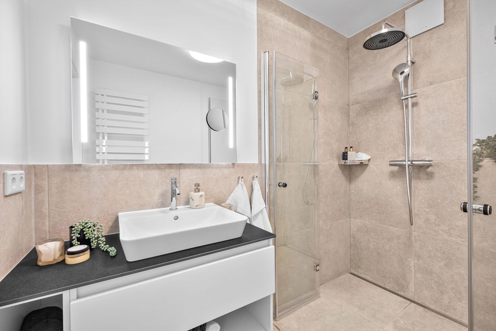Bad mit Dusche, Waschbecken und Spiegel
