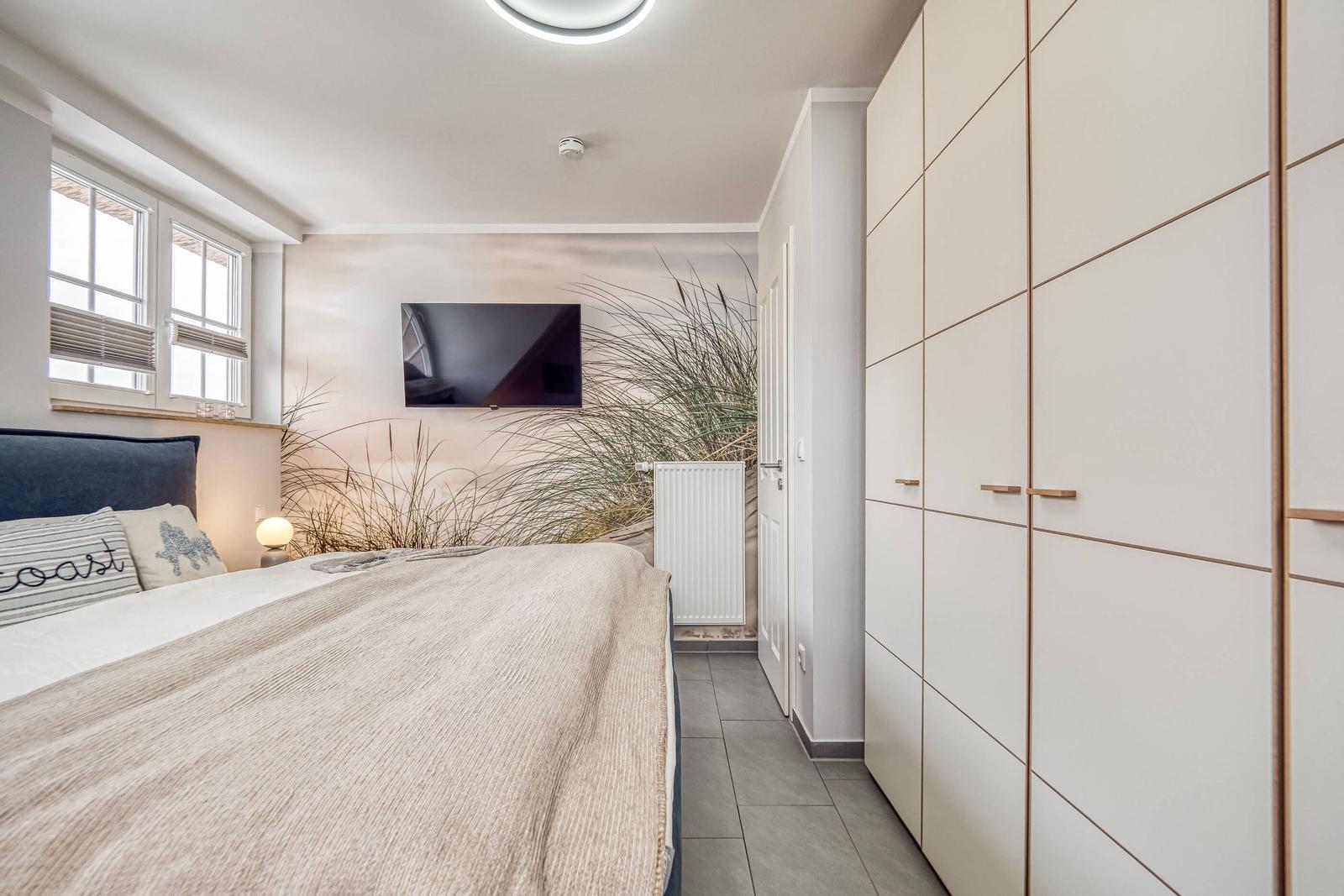 Schlafzimmer mit Kleiderschrank und TV