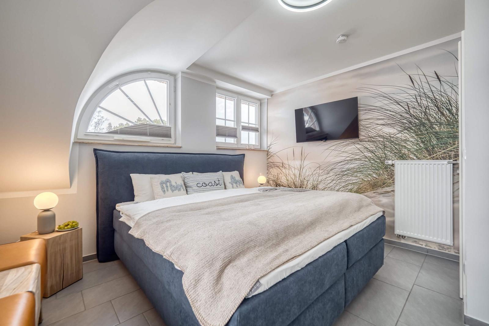 Schlafzimmer mit Doppelbett und TV
