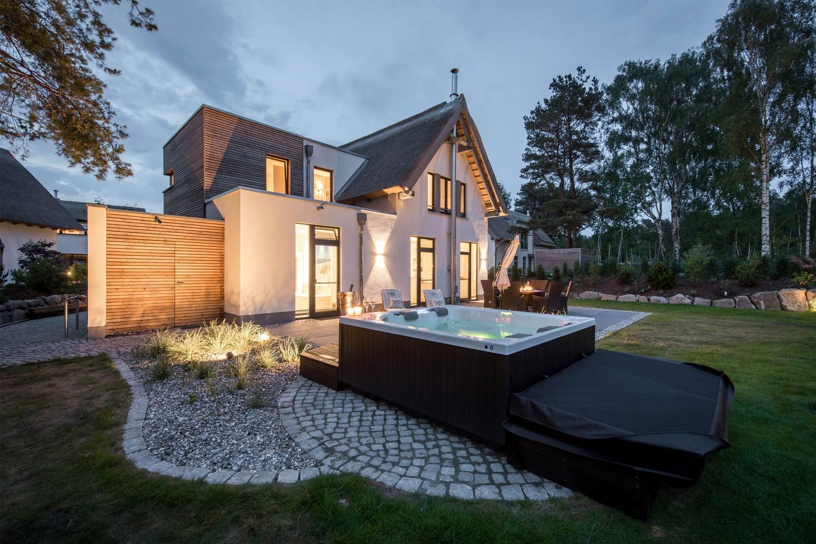 Moderne Villa mit Whirlpool, Garten und Holzverkleidung. Außenbereich mit Sitzgelegenheiten.