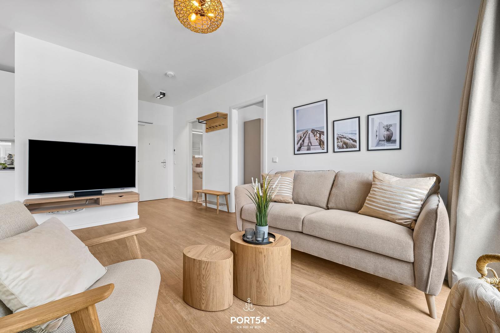 Living room with sofa, TV, and wooden tables.