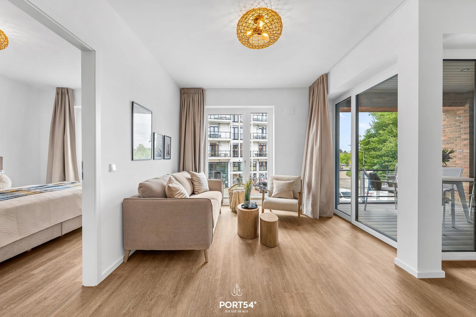 Living room with sofa, seating area, and view of balcony and buildings.