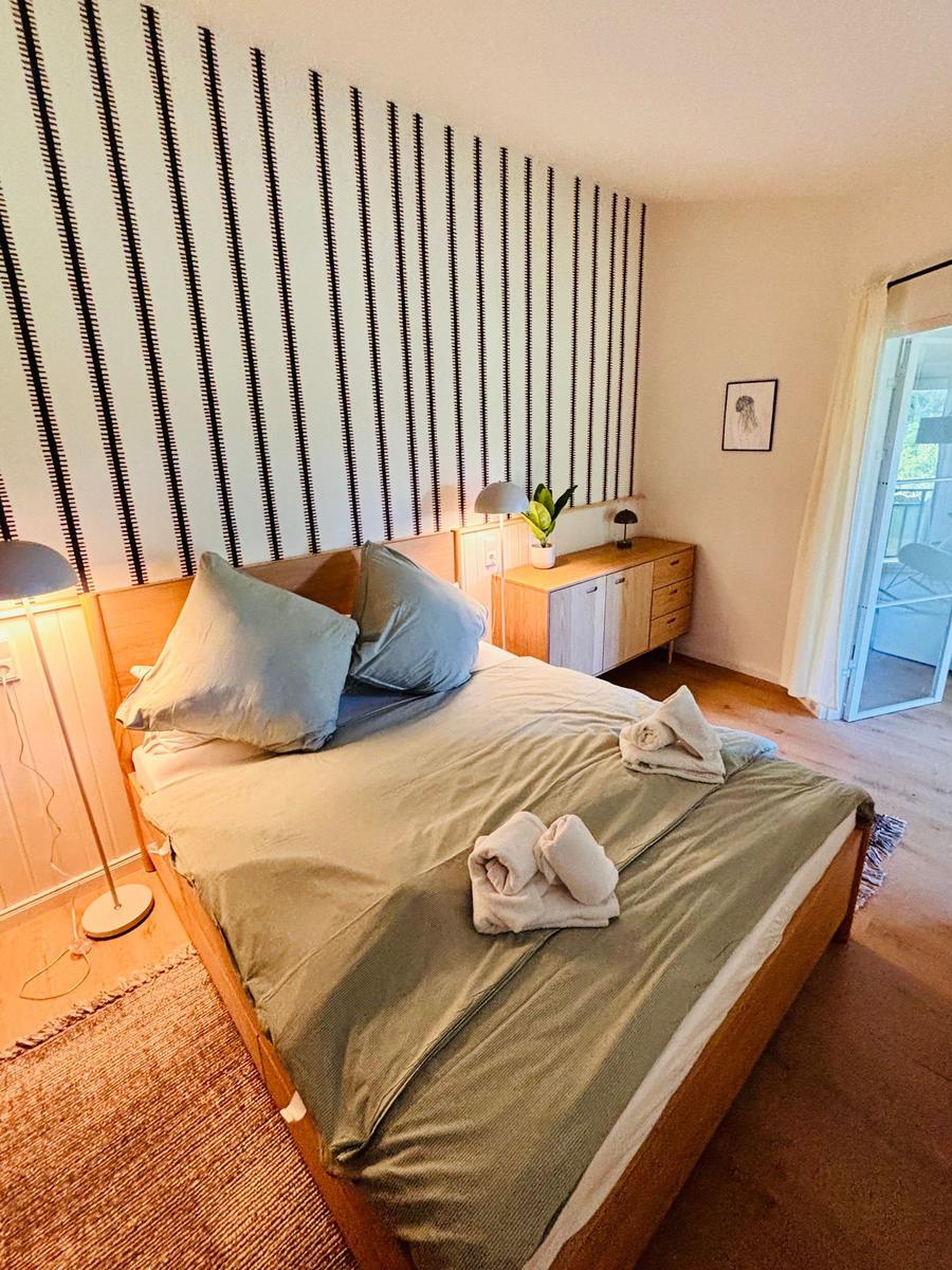 Schlafzimmer mit Bett, Nachttisch und Schlafzimmermöbeln.