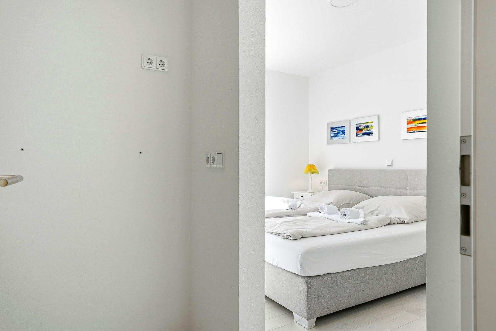 Ein Schlafzimmer mit Bett, Nachttisch und Wandbildern.