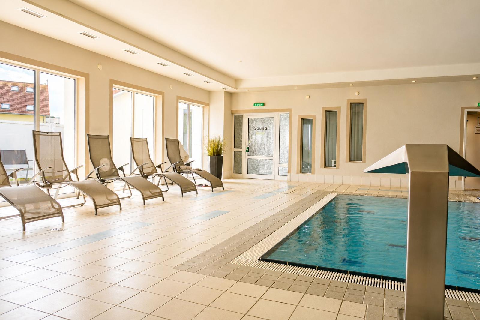 Innenpool mit Liegestühlen und Sauna-Eingang
