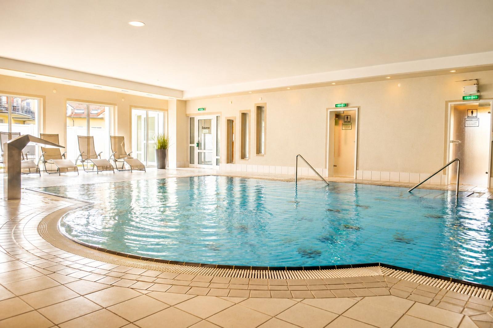 Innenpool mit Liegestühlen und Sauna-Eingang