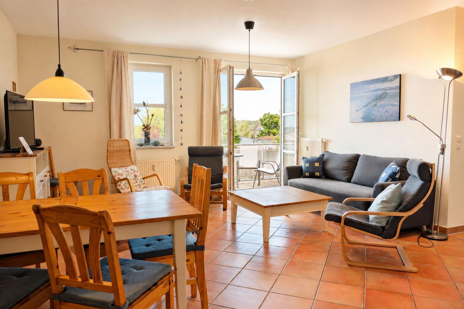 Wohn- und Essbereich mit Holztisch, Sofa und Terrassentür.