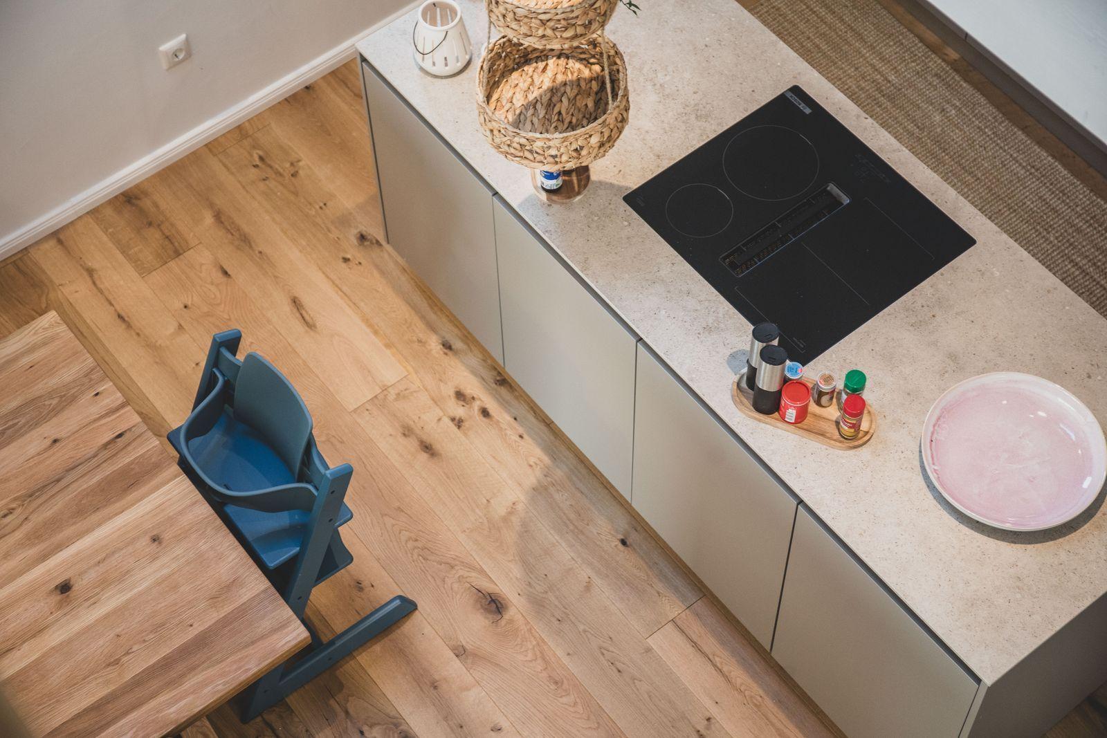 Küche mit Arbeitsplatte, Induktionskochfeld und Kindersitz.