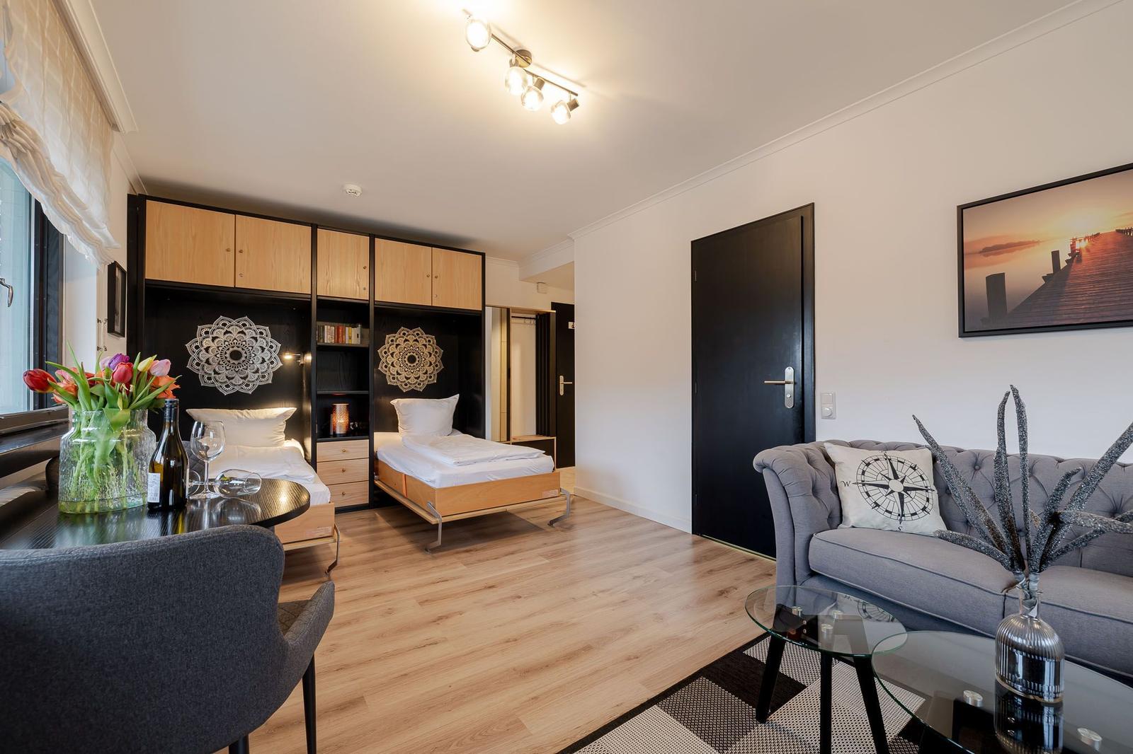 A bedroom with two beds and a living area with sofa and coffee table.