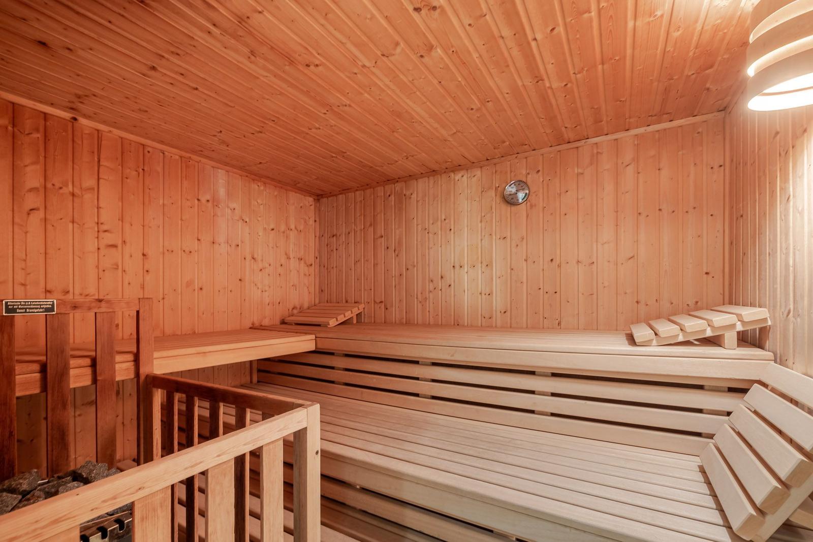 Sauna mit Holzbanken und Temperaturanzeige an der Wand