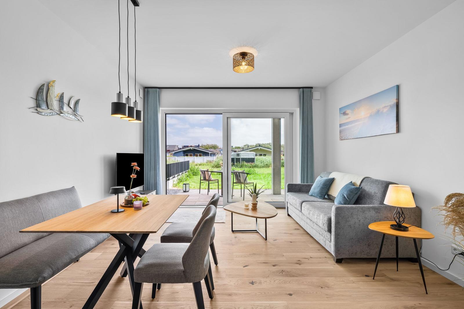Wohn- und Essbereich mit Sofa, Esstisch und Terrassentür.