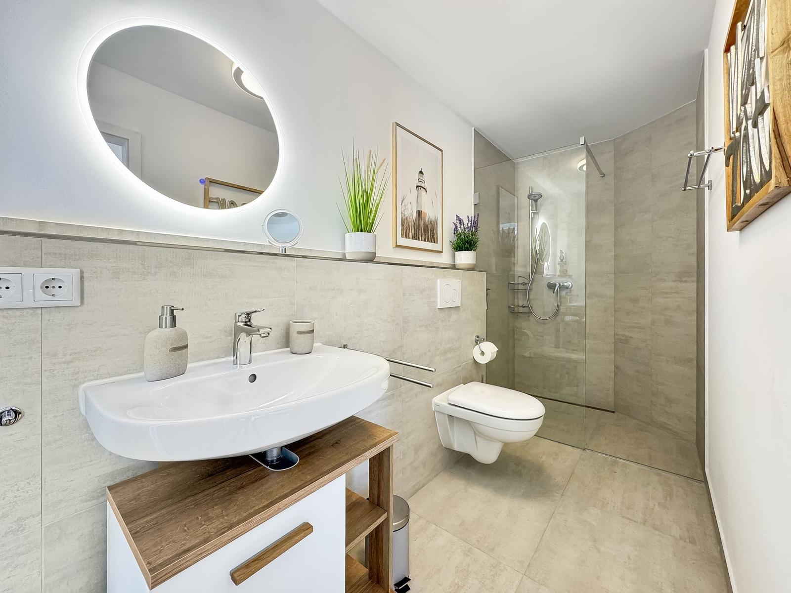 Badezimmer mit Dusche, Waschbecken und Toilette. Moderne Einrichtung mit Holz- und Steinoptik.