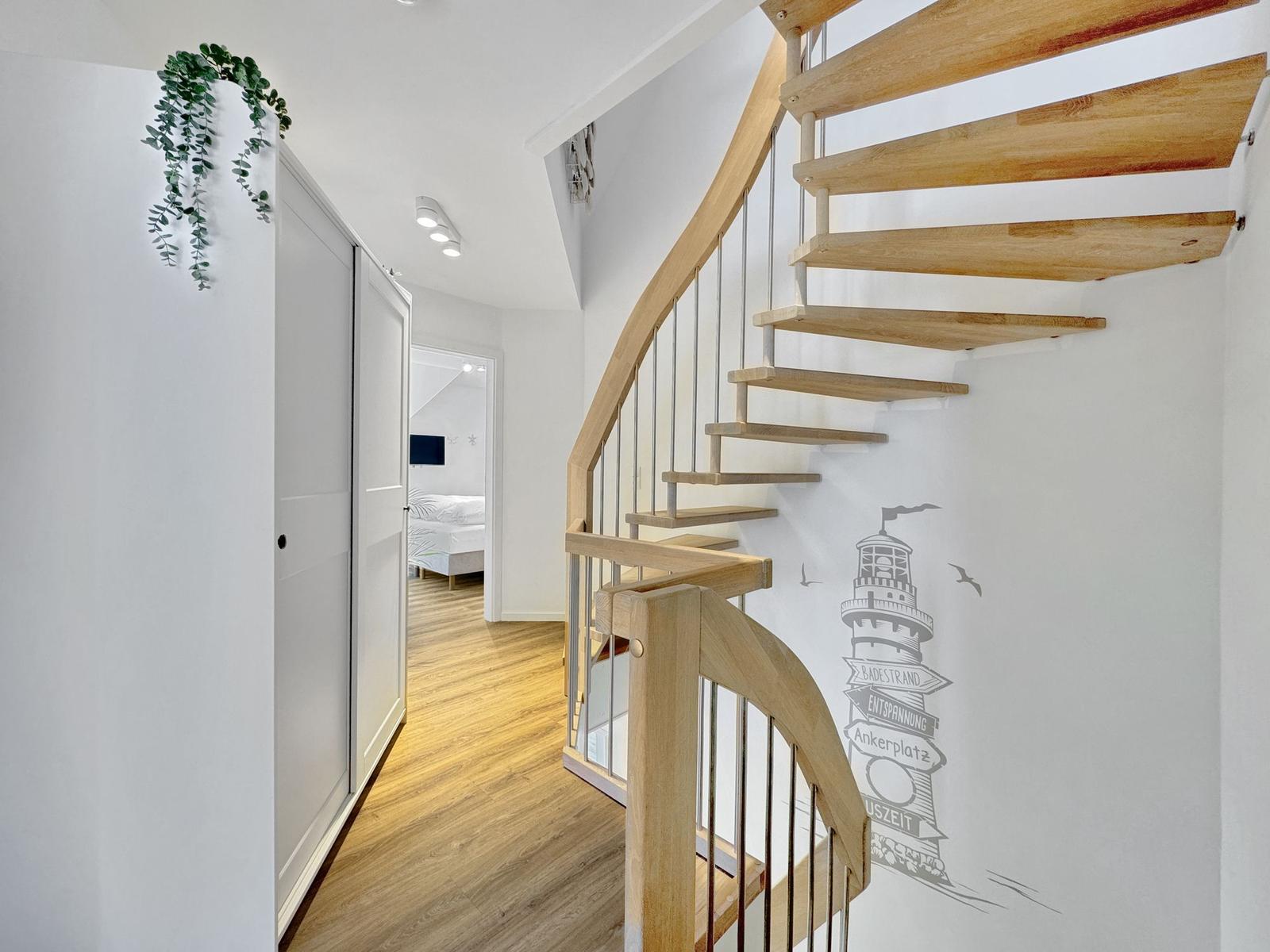 Haus mit Holztreppe und Lighthouse-Wandtattoo. Blick in Schlafzimmer mit Bett.
