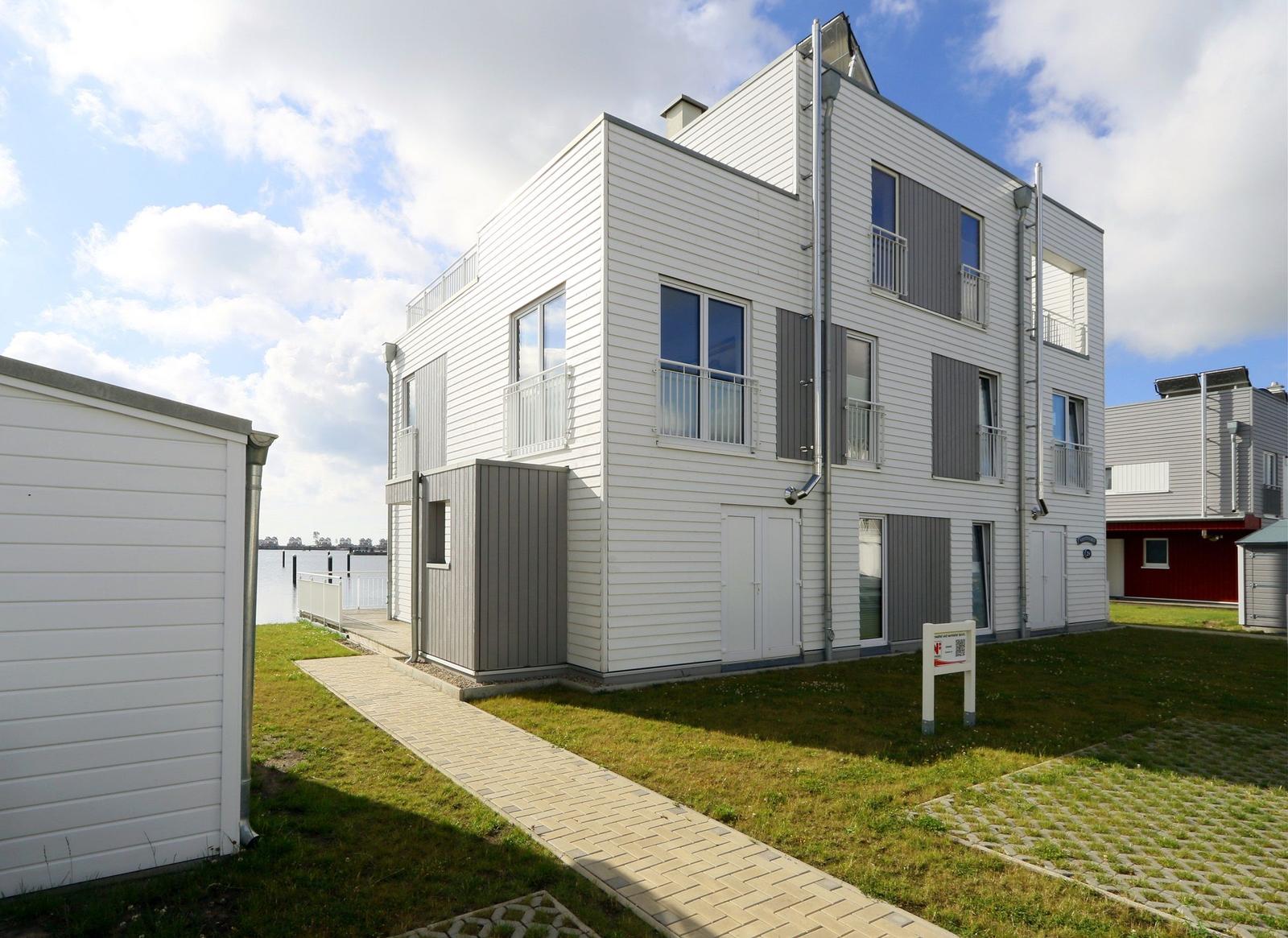 Moderne Ferienwohnung mit Balkonen und direktem Blick auf Wasser.