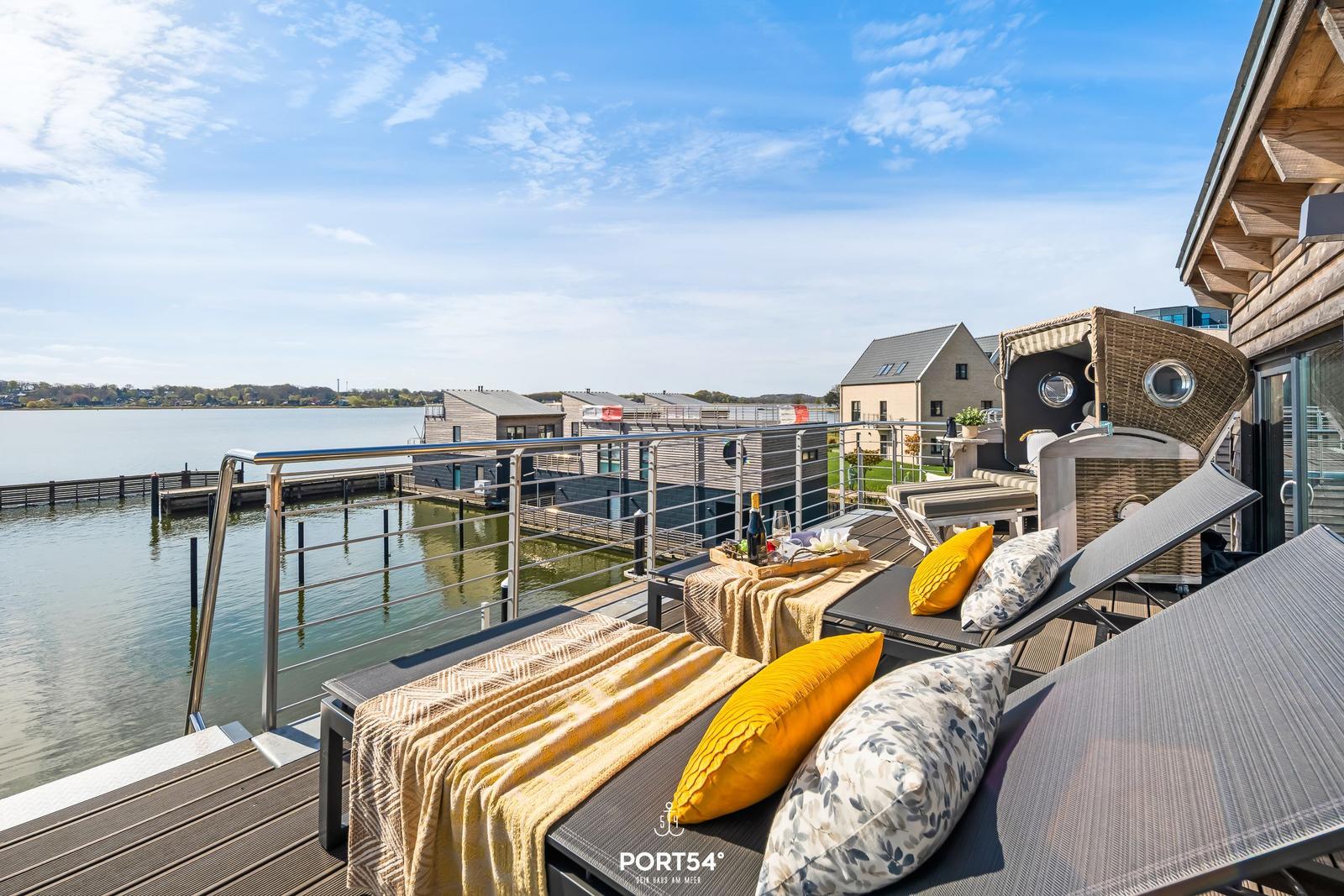 Terrasse mit Liegen und Blick auf Wasser und Häuser