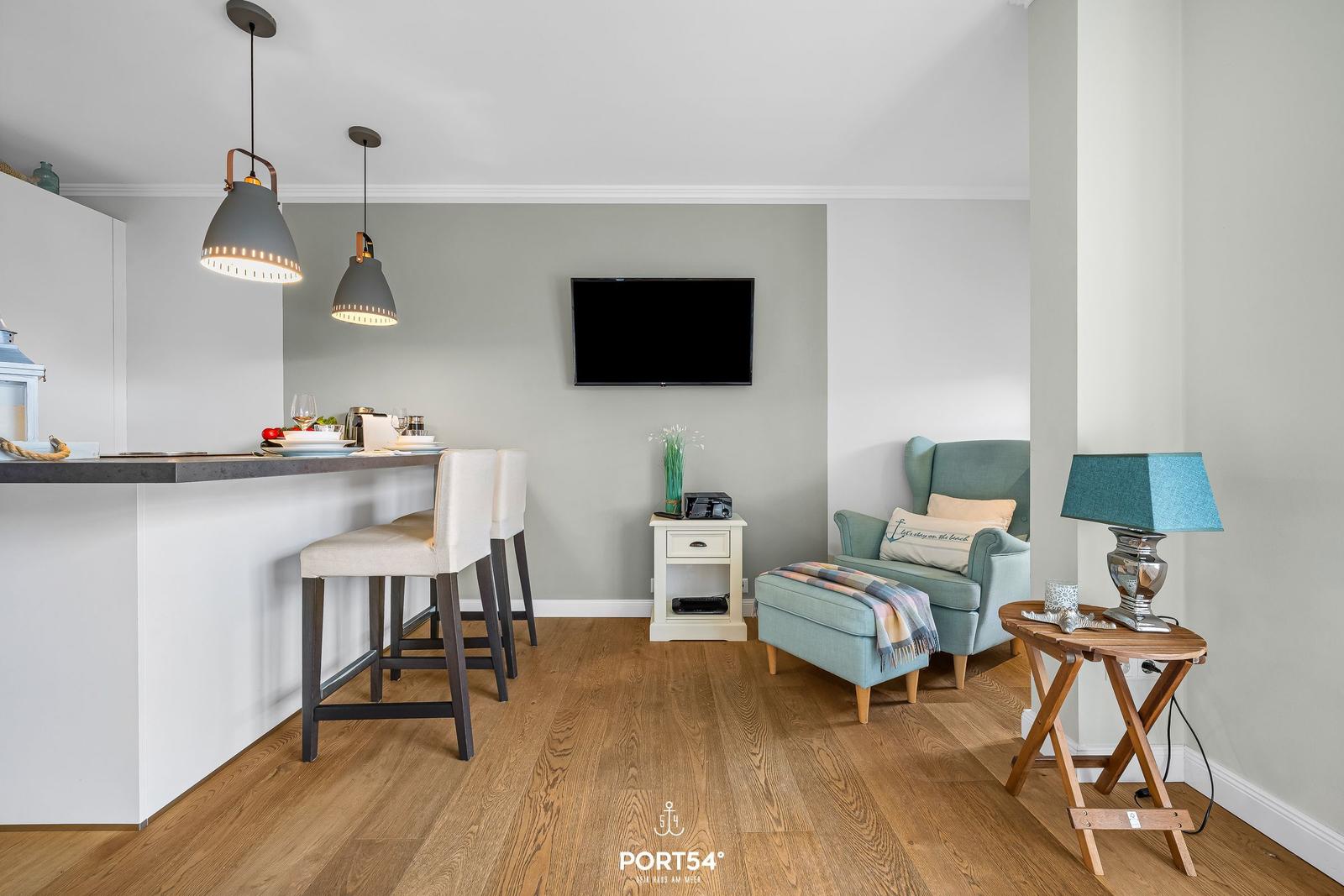 Küche mit Sitzgelegenheit und Fernseher an der Wand