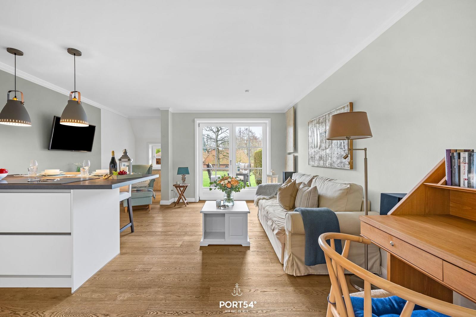 Wohnbereich mit Sofa, Esstisch und Blick auf Garten