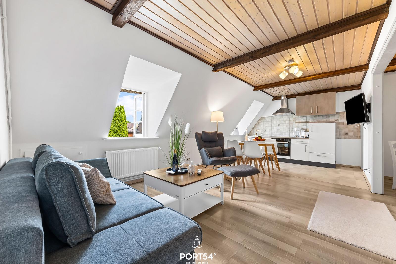 Wohn- und Essbereich mit Küche unter holzverkleidetem Dach