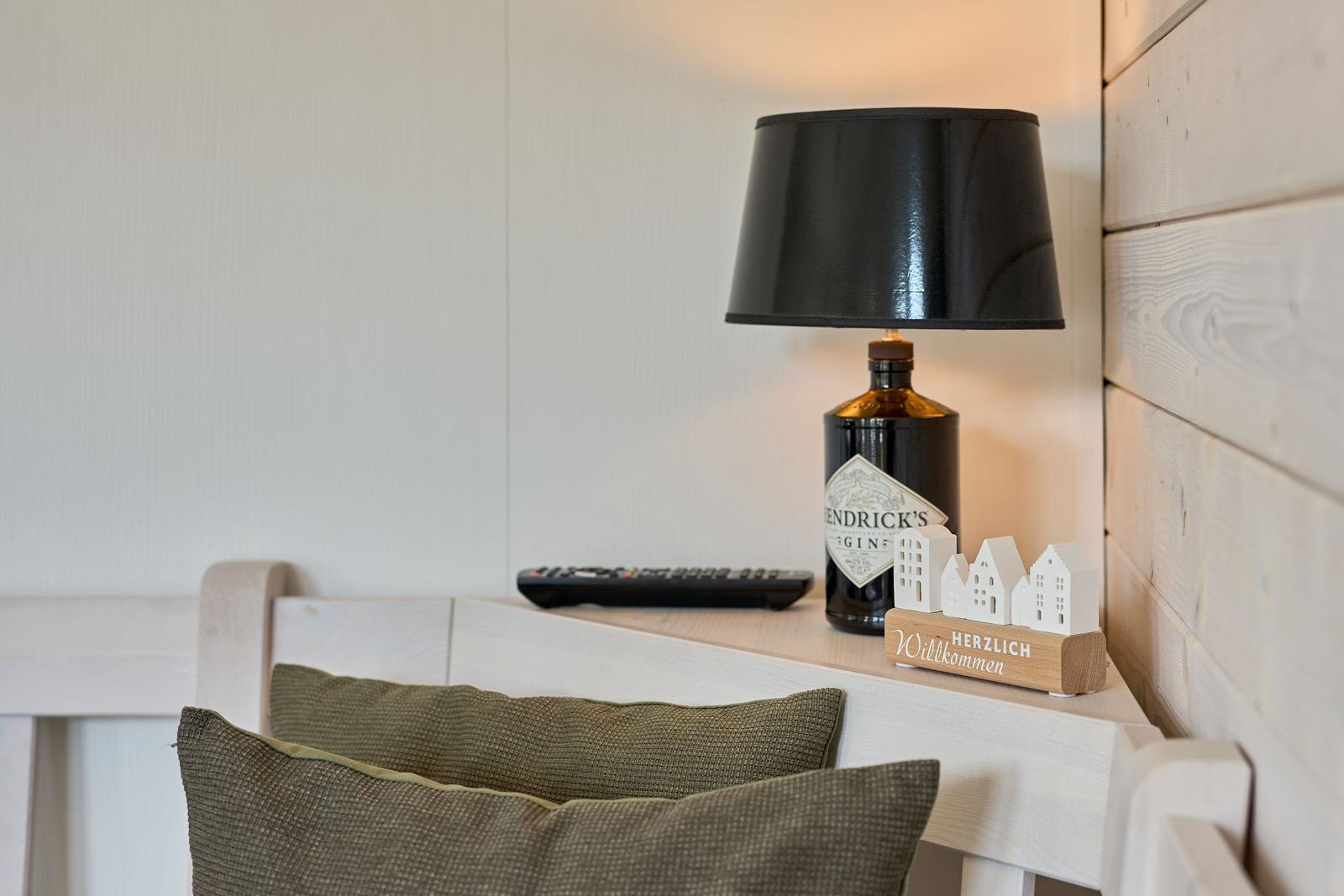 Schreibtisch mit Lampe, Fernbedienung und Willkommensschild