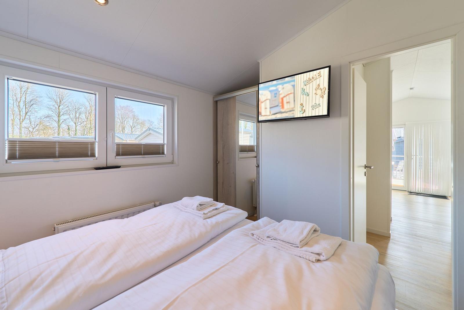 Zimmer mit zwei Betten, TV und Fenster zur Aussicht.