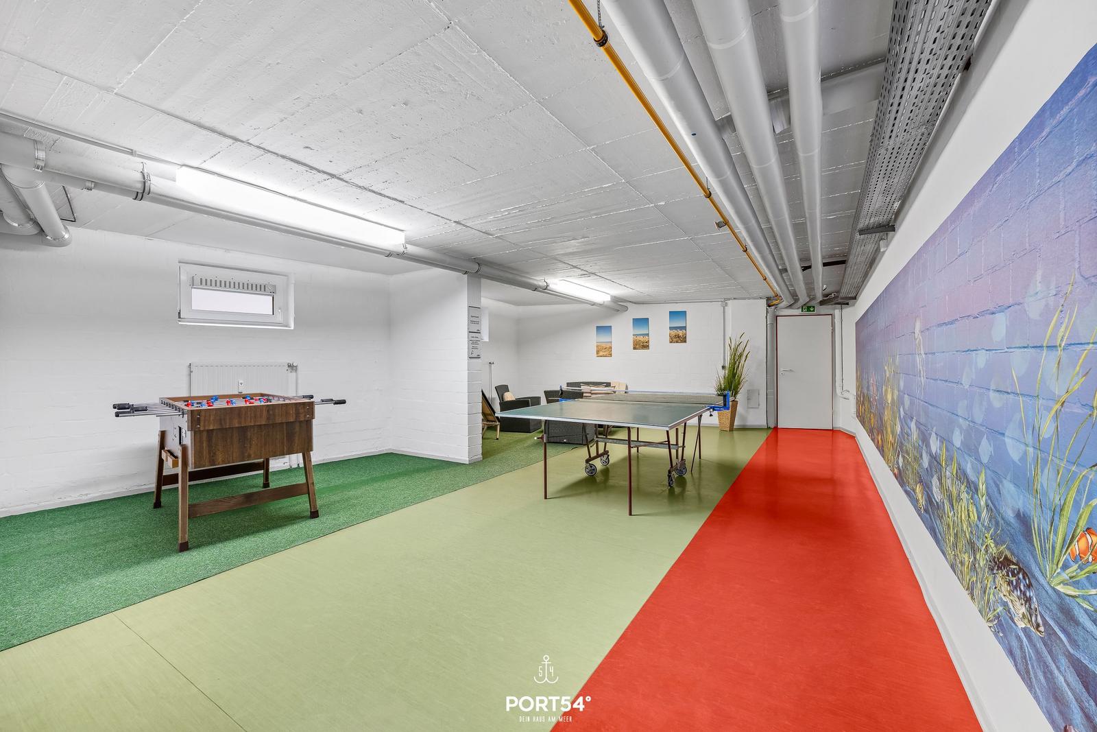 Raum mit Tischtennisplatte, Fussballtisch und Wandmalerei