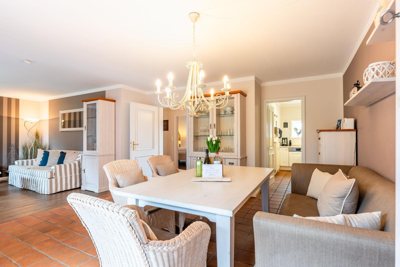 Esszimmer mit Esstisch, Stühlen und Wohnbereich mit Sofa und Beistelltisch.