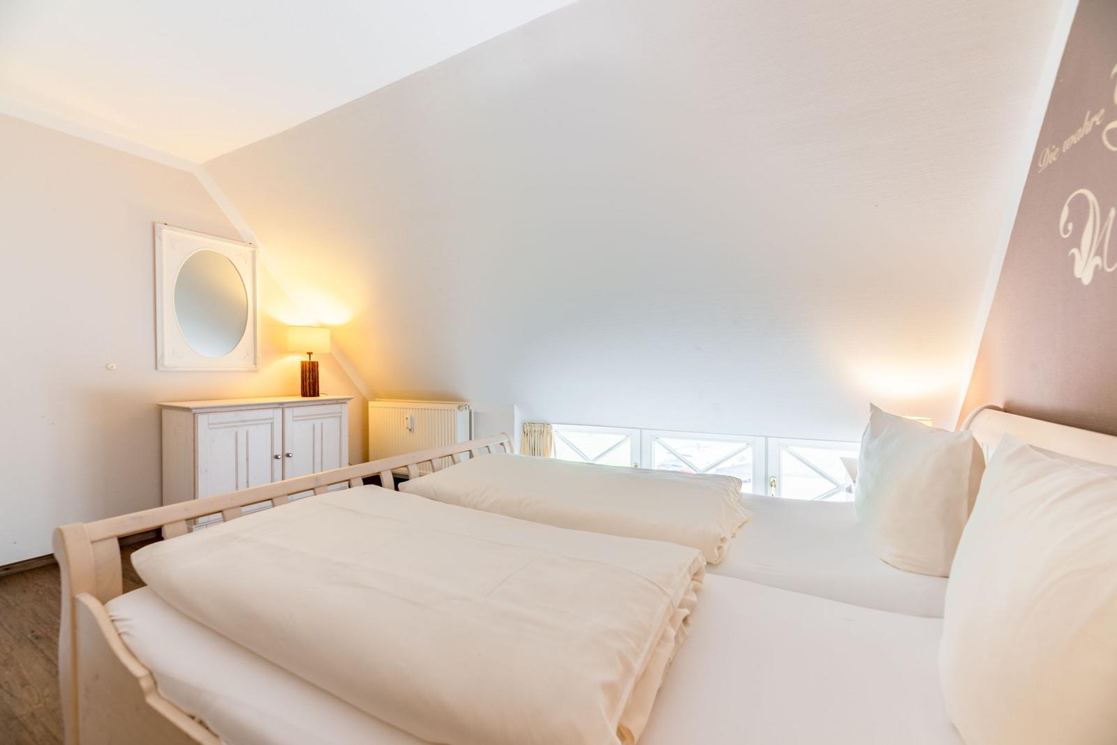Schlafzimmer mit Doppelbett, Nachttisch und Fenster