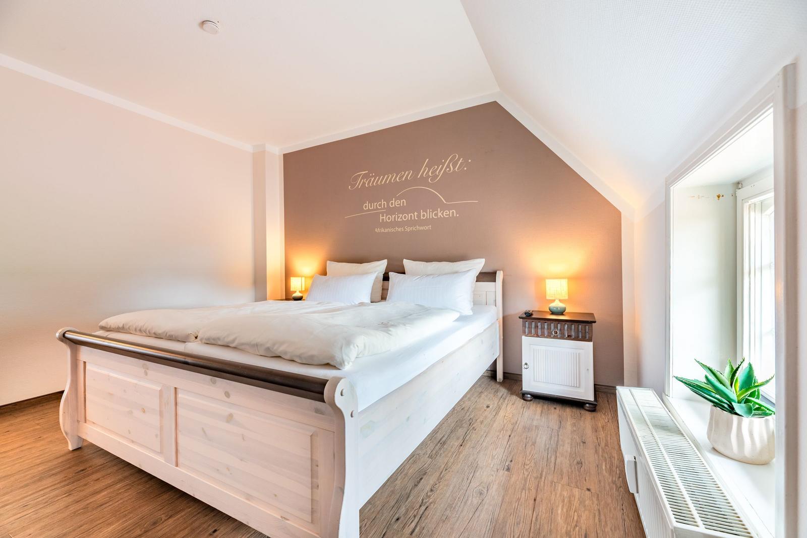 Schlafzimmer mit Bett, Nachttisch und Wanddekoration.