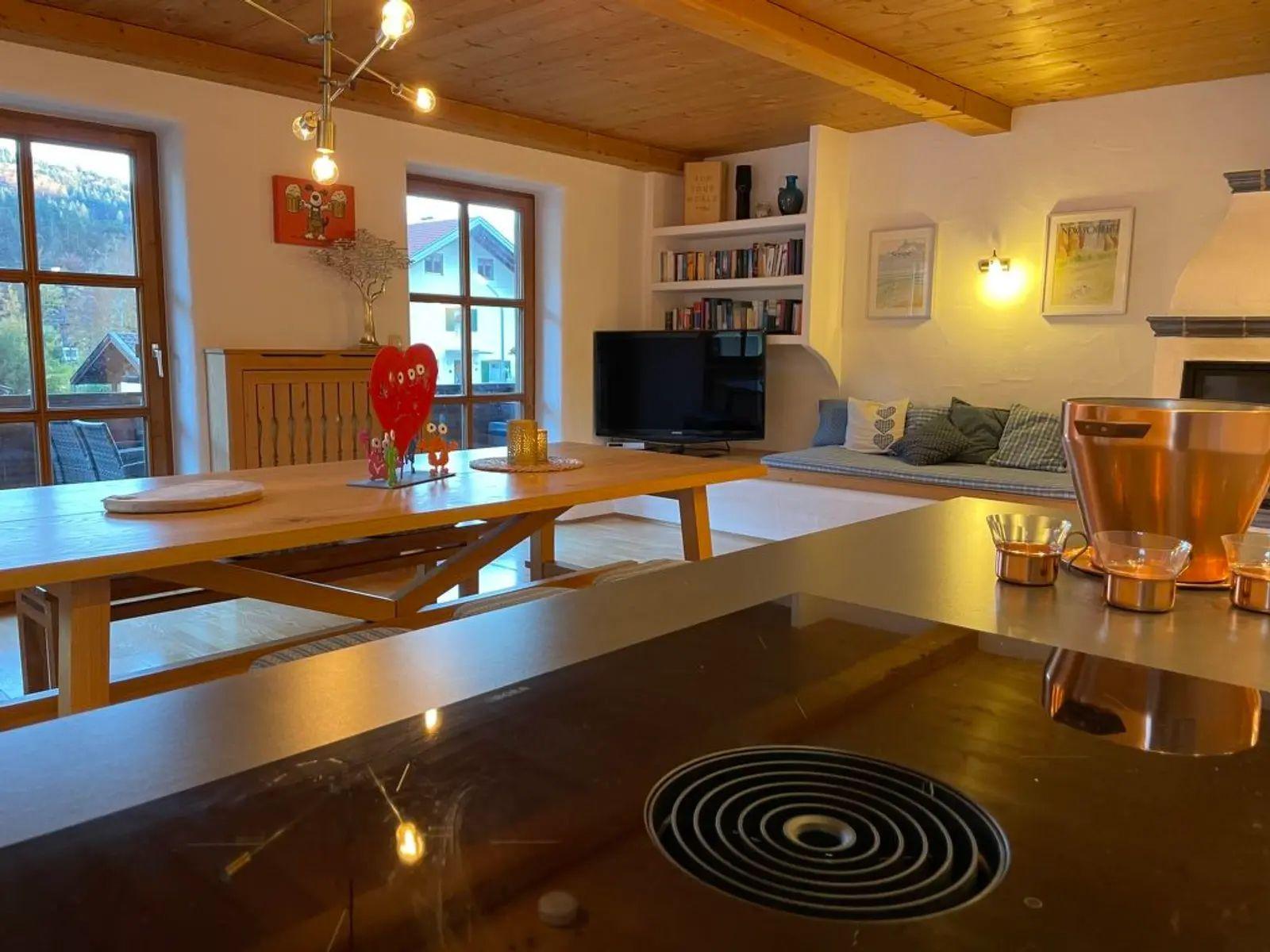 Küche mit Esstisch, Wohnbereich mit Sofa und Kamin