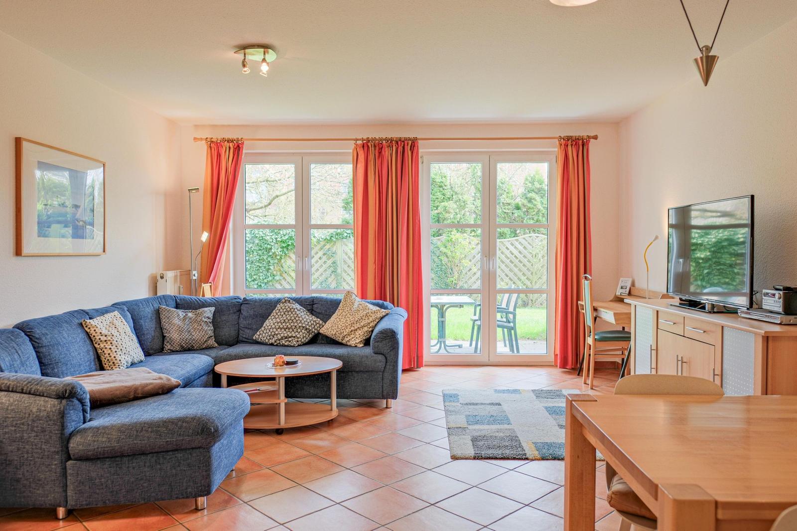 Wohnzimmer mit Sofa, Couchtisch und Blick auf den Garten.