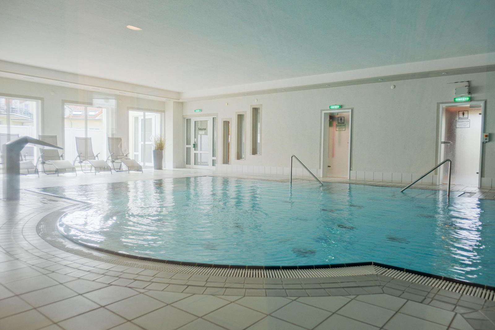 Innere Schwimmbad mit Liegestühlen und Sauna-Eingang