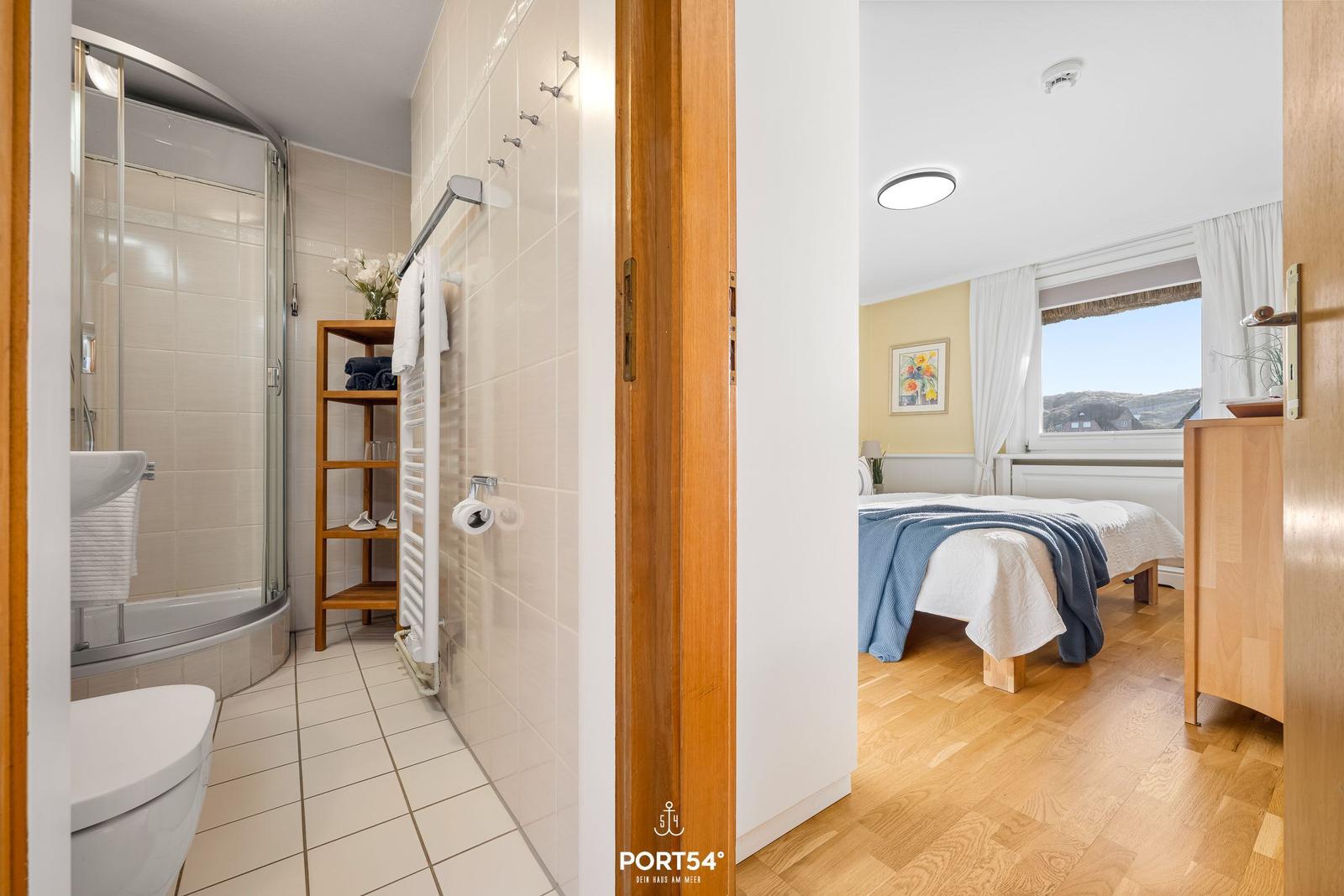 Badezimmer mit Dusche und Schlafzimmer mit Blick auf die Landschaft.