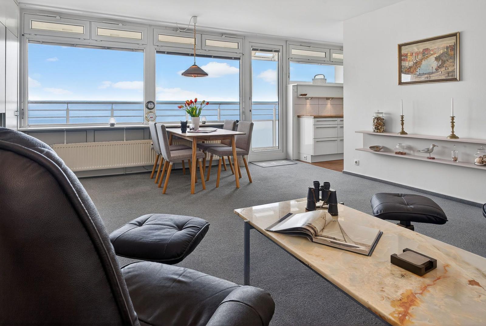 Apartment with sea view, dining table, sofa, and kitchen area