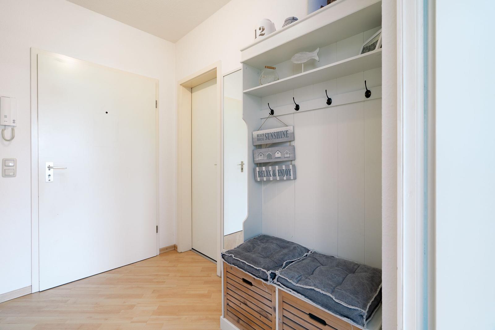 Eingangsbereich mit Garderobe, Sitzbank und Tür