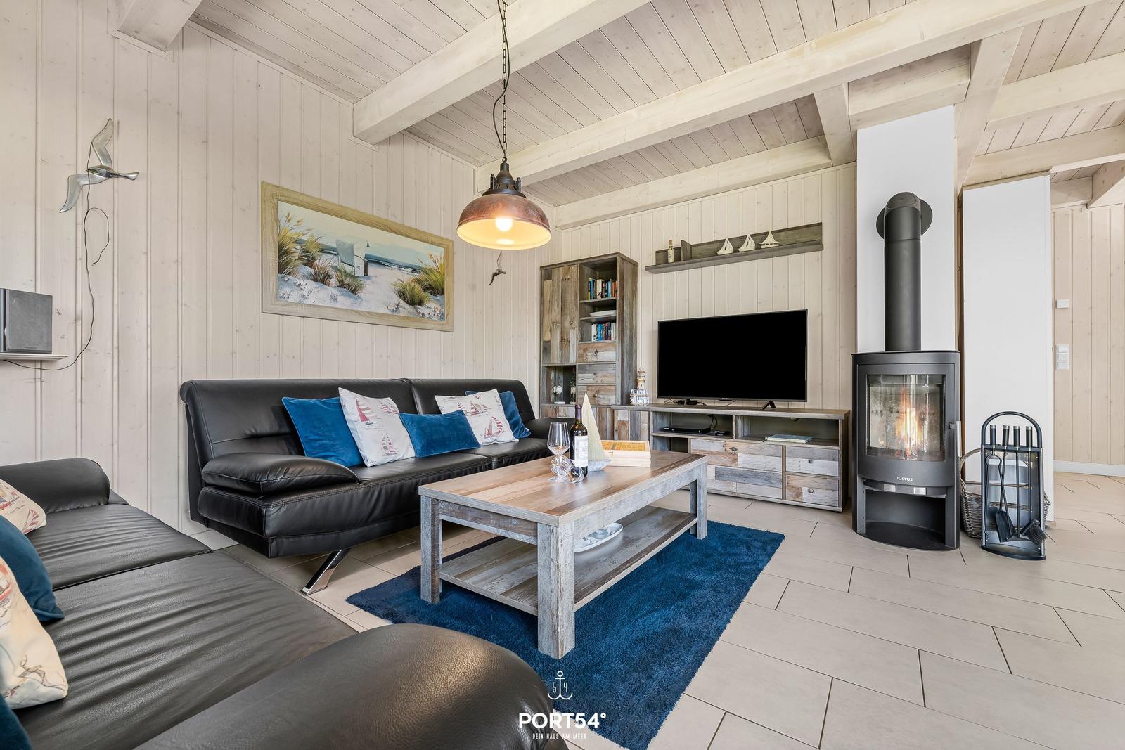 Wohnzimmer mit Sofa, Kamin und Fernseher