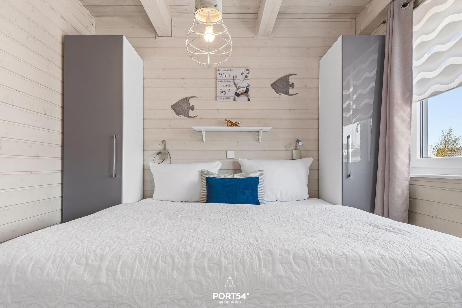 Schlafzimmer mit Bett, Wandregal und Fenster. Holzwände und moderne Möbel.