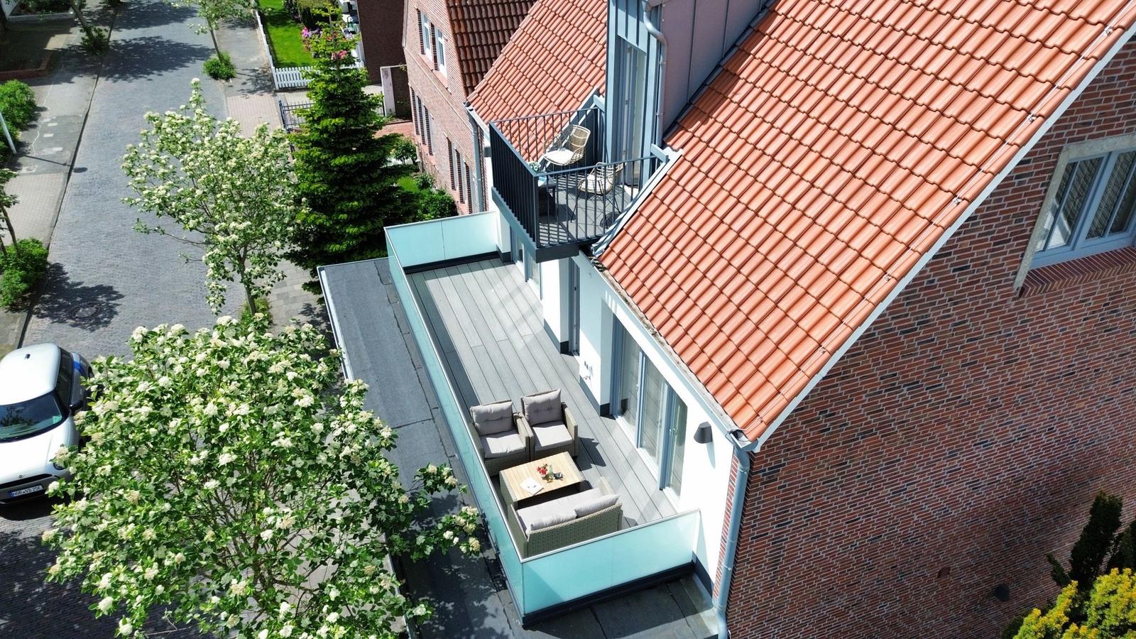 Terrasse mit Sitzmöbeln und Blick auf Straße und Bäume