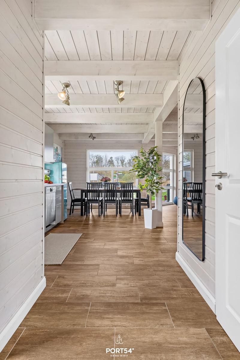 Haus mit Holzboden, weißen Wänden und Essbereich mit Tisch und Stühlen.